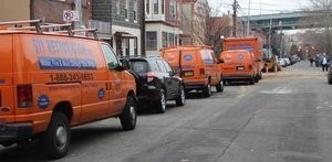 Mold and Water Damage Restoration Vans And Trucks Lined Up At Urban Job Location