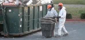 Water Damage Technicians Removing Debris To Street Dumpster